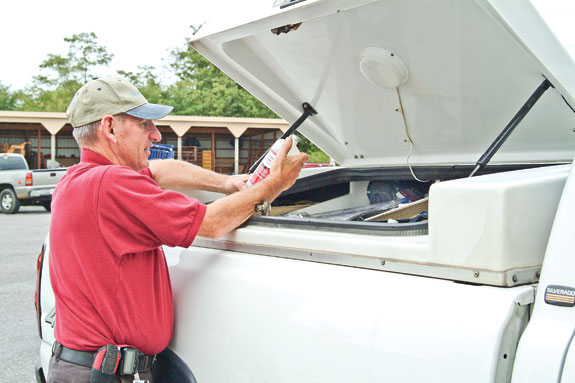 A man opens the covered bed of a pickup truck