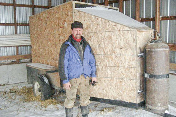 IX Ranch Manager Todd Amsbaugh is pictured with the mobile warming box he designed and built for multiple-calf use on Montana’s expansive IX Ranch